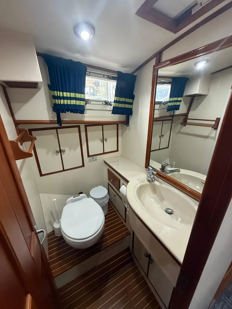 Slide: The Image of Luxurious 2002 Grand Banks 43 Eastbay HX yacht bathroom with sink, toilet, and wooden accents. - 29