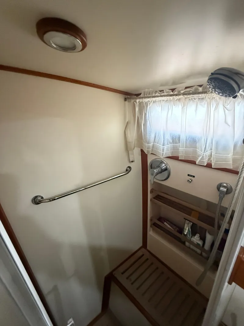 Slide: The Image of Shower area in 2002 Grand Banks 43 Eastbay HX yacht with wooden accents and storage shelves. - 30