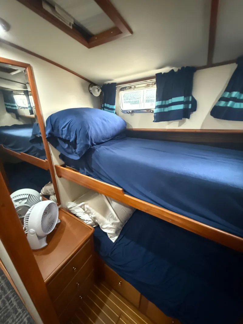 Slide: The Image of Bunk beds in 2002 Grand Banks 43 Eastbay HX cabin with blue bedding and wooden interior. - 31