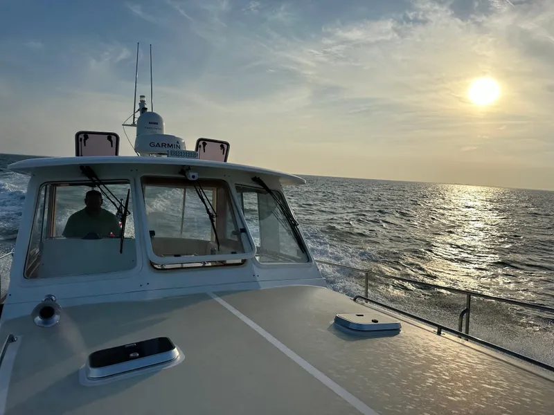 Slide: The Image of 2002 Grand Banks 43 Eastbay HX cruising at sunset on open water. - 4