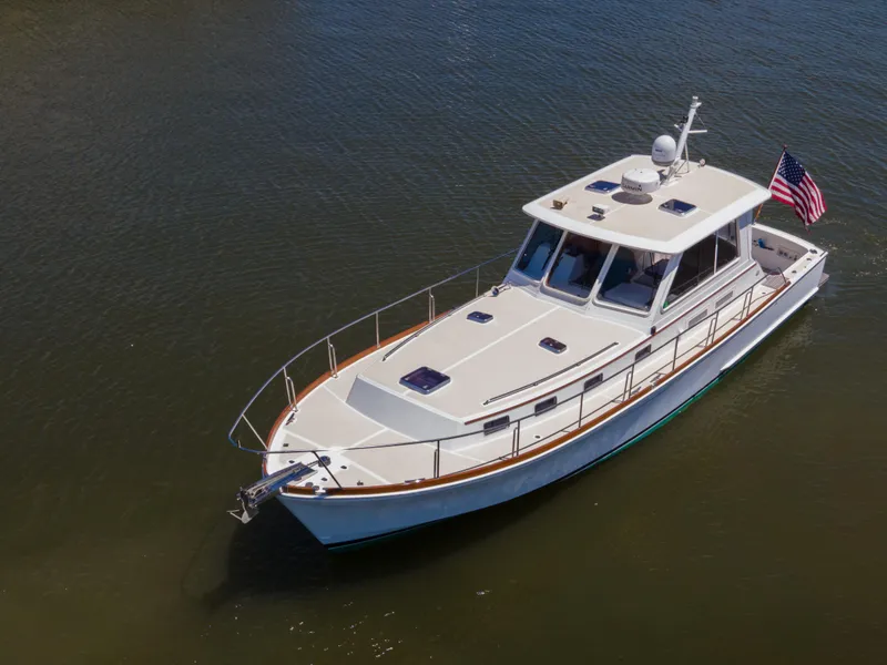 Slide: The Image of 2002 Grand Banks 43 Eastbay HX yacht on calm water with American flag. - 6