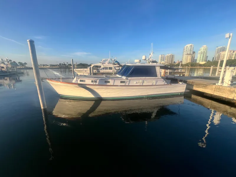Slide: The Image of 2002 Grand Banks 43 Eastbay HX yacht docked in a marina with city skyline. - 9