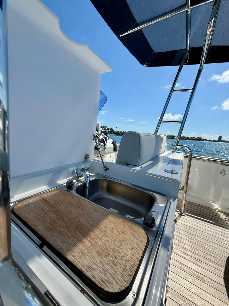 Slide: The Image of 2019 Fjord 36' Open yacht with outdoor sink and seating, under a clear blue sky. - 13