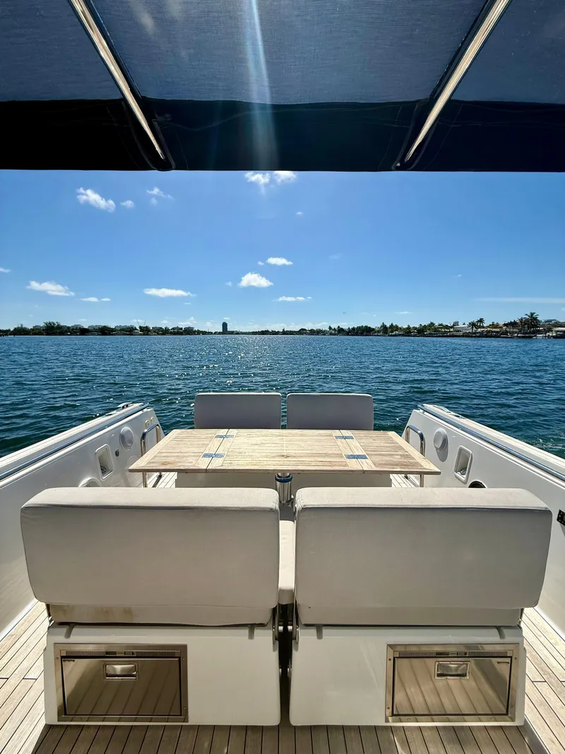 Slide: The Image of 2019 Fjord 36' Open yacht with seating and table, overlooking serene blue waters. - 14