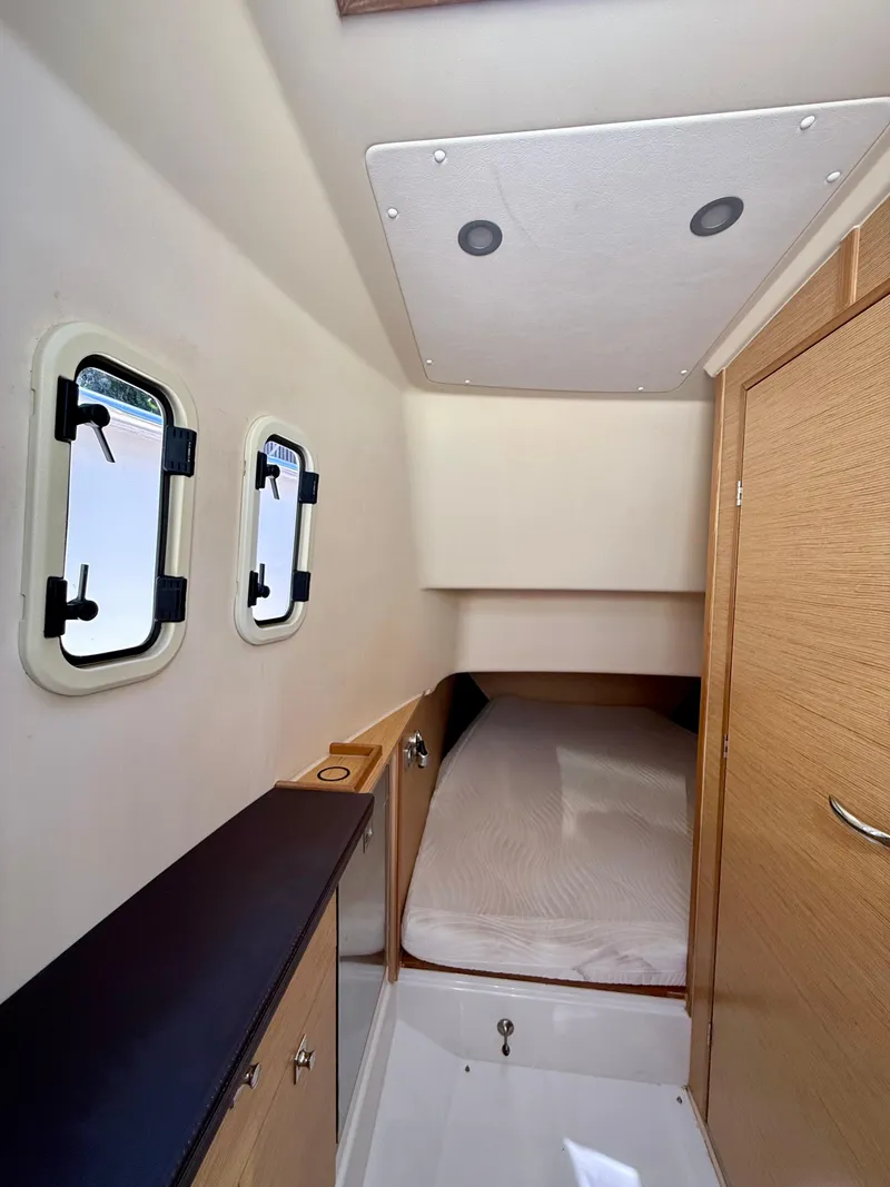 Slide: The Image of 2019 Fjord 36' Open cabin interior with bed, wooden cabinetry, and porthole windows. - 18