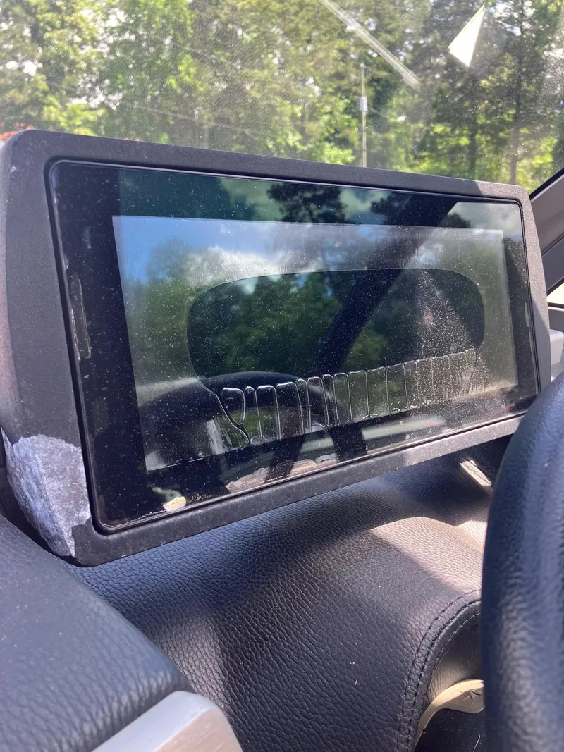 Slide: The Image of Dashboard screen of a 2019 Malibu Wakesetter 22 MXZ boat, reflecting trees. - 18
