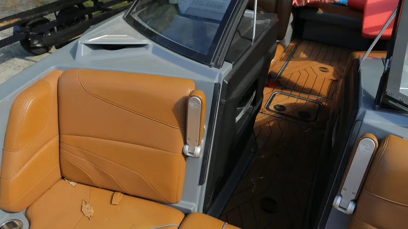 Slide: The Image of 2019 Malibu Wakesetter 22 MXZ interior with tan leather seats and wood-patterned flooring. - 21