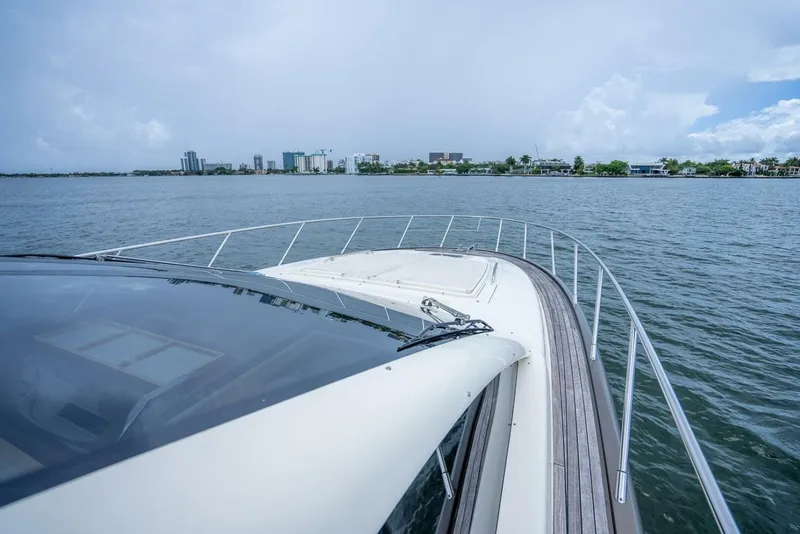 Slide: The Image of 2012 Riva Sport 56 yacht cruising on calm waters near a city skyline. - 13