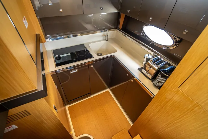 Slide: The Image of Compact kitchen in 2012 Riva Sport 56 yacht with modern appliances and wooden cabinetry. - 28