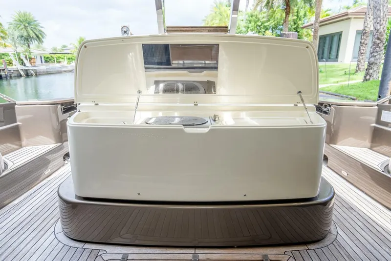Slide: The Image of Open storage compartment on 2012 Riva Sport 56 yacht deck, surrounded by lush greenery. - 11