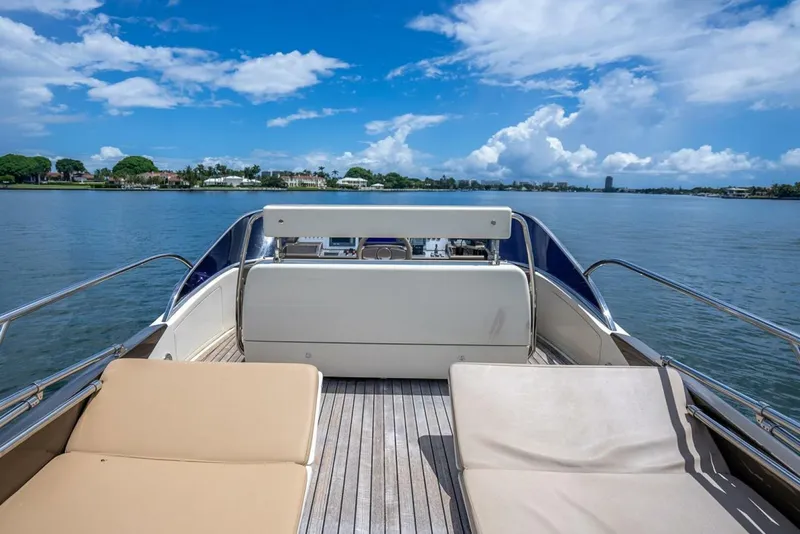 Slide: The Image of Luxurious 2012 Riva Sport 56 yacht deck with sun loungers, overlooking serene waters and blue sky. - 19