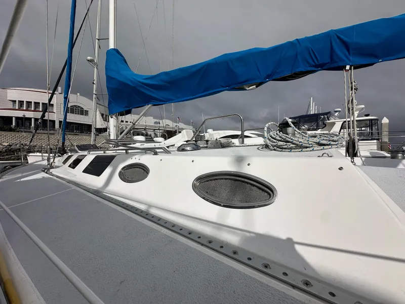 Slide: The Image of 1987 Hunter Legend 45 sailboat with blue cover docked at marina. - 10