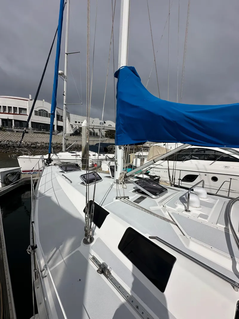 Slide: The Image of 1987 Hunter Legend 45 sailboat with blue sail cover docked at marina. - 11
