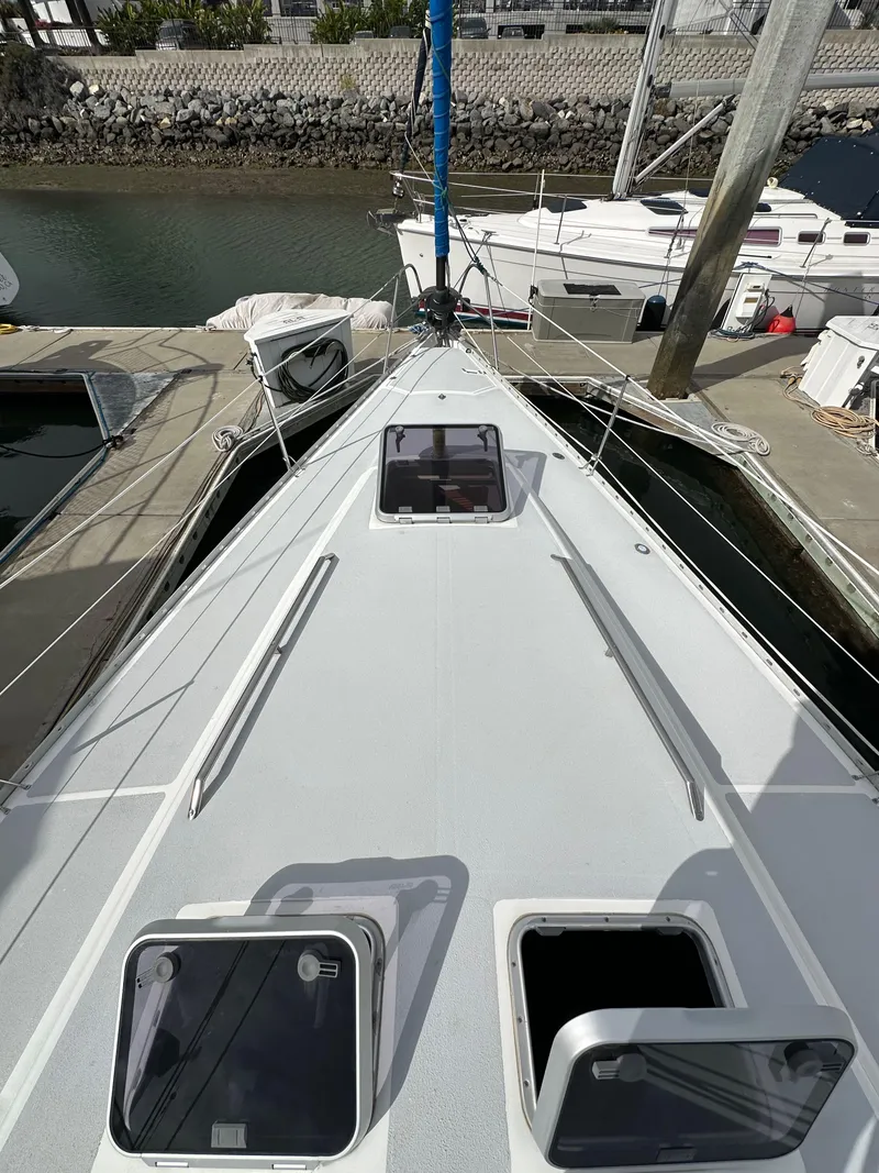 Slide: The Image of 1987 Hunter Legend 45 sailboat docked, view from deck showing open hatches and marina surroundings. - 12