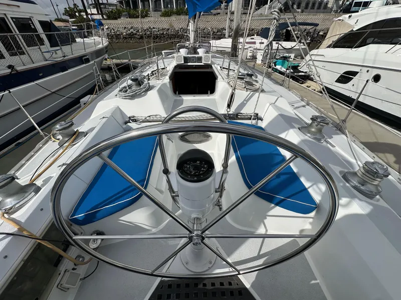 Slide: The Image of 1987 Hunter Legend 45 sailboat deck with steering wheel and blue seating. - 20