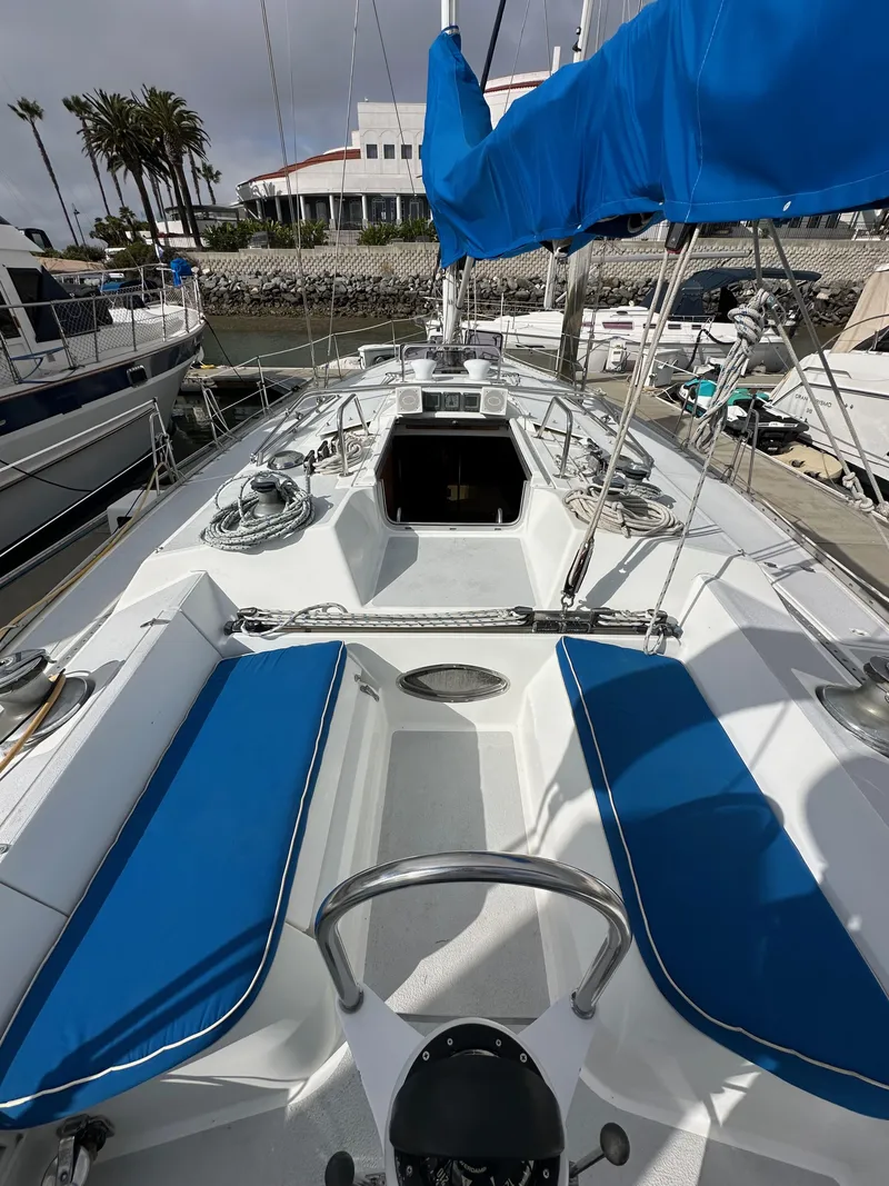 Slide: The Image of 1987 Hunter Legend 45 sailboat with blue accents docked at a marina. - 23
