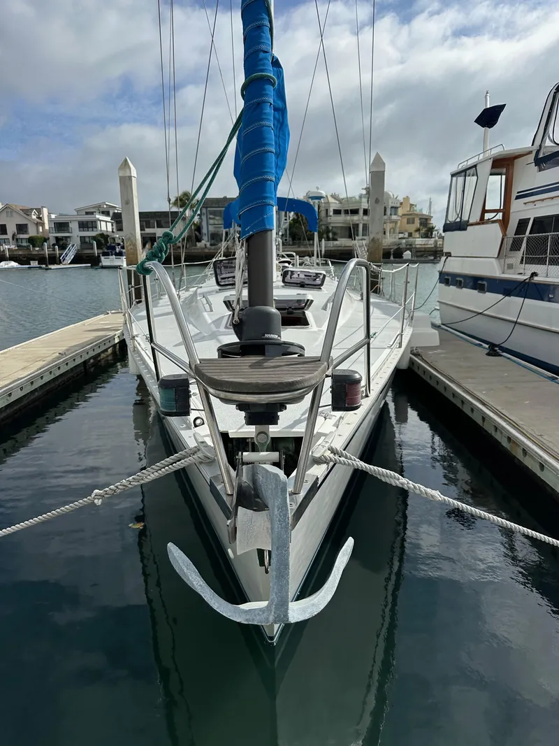 Slide: The Image of 1987 Hunter Legend 45 sailboat docked in marina, front view with blue sail cover. - 3