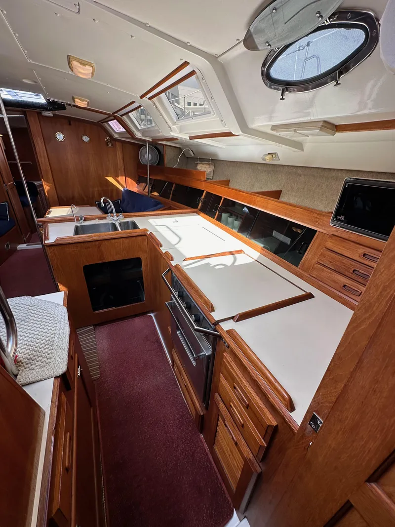 Slide: The Image of Interior of 1987 Hunter Legend 45 sailboat, featuring a spacious kitchen with wooden cabinetry. - 35