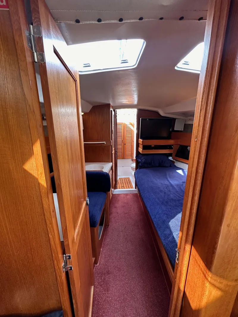 Slide: The Image of Interior of 1987 Hunter Legend 45 sailboat with wood paneling and cozy sleeping area. - 48