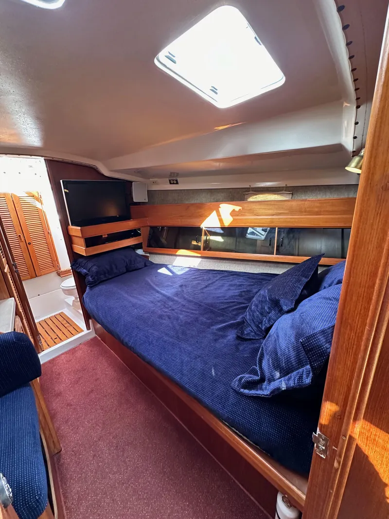 Slide: The Image of Cozy cabin interior of 1987 Hunter Legend 45 sailboat with blue bedding and wooden accents. - 49