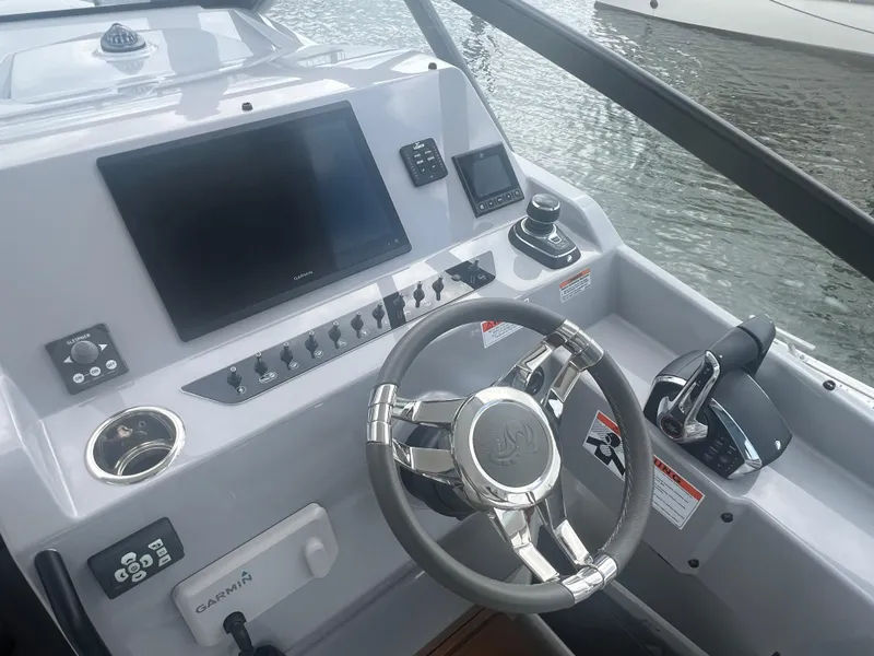 Slide: The Image of 2025 Beneteau Flyer 10 helm with Garmin display and modern controls on water. - 15
