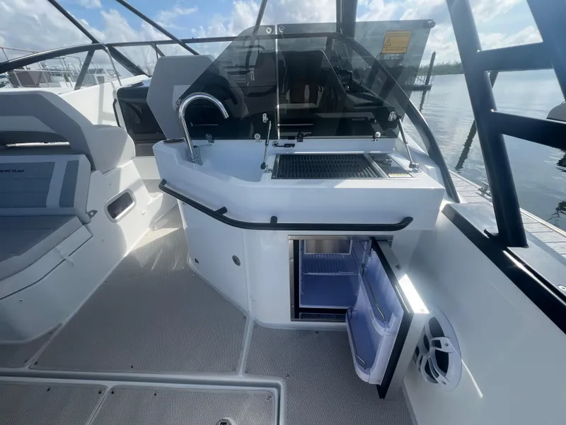 Slide: The Image of 2025 Beneteau Flyer 10 boat interior with kitchenette and open mini fridge. - 16