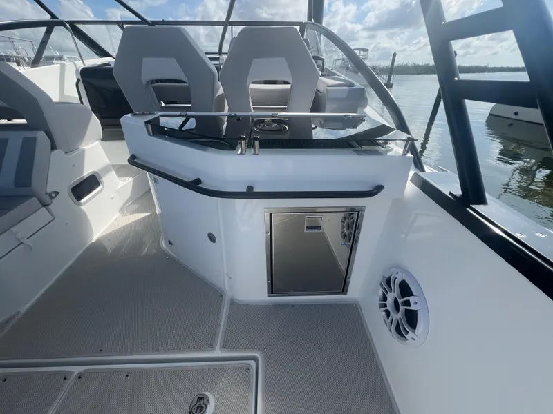 Slide: The Image of 2025 Beneteau Flyer 10 boat interior with seating and storage, docked on a sunny day. - 17