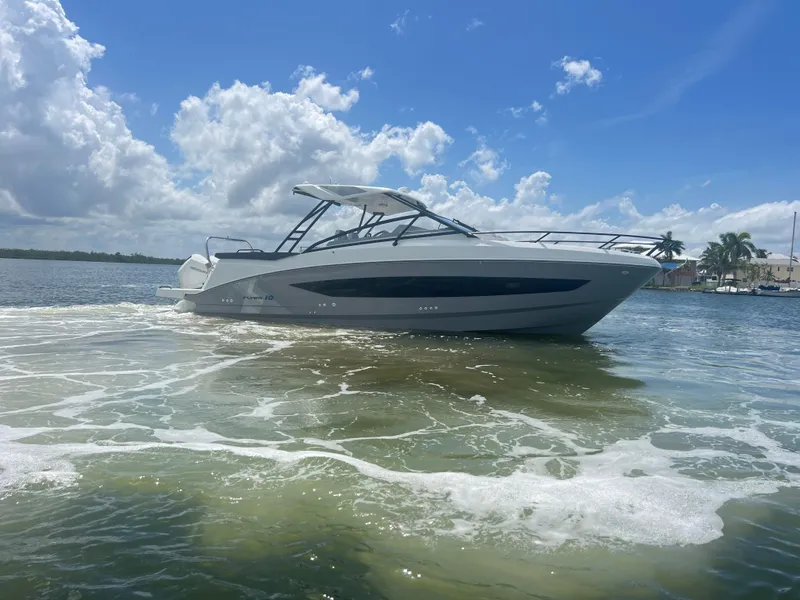 Slide: The Image of 2025 Beneteau Flyer 10 boat on water under blue sky and clouds. - 2