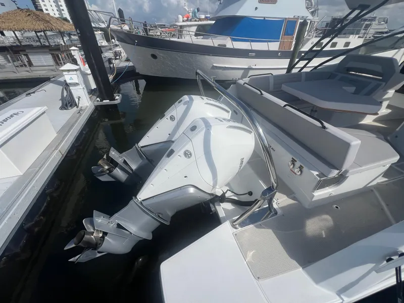 Slide: The Image of 2025 Beneteau Flyer 10 with dual outboard engines docked at marina. - 21