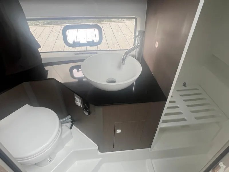 Slide: The Image of 2025 Beneteau Flyer 10 bathroom with modern sink, toilet, and window view. - 26