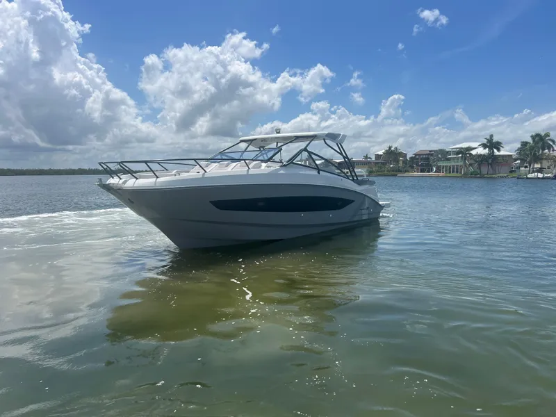 Slide: The Image of 2025 Beneteau Flyer 10 boat on calm water under a clear blue sky. - 4