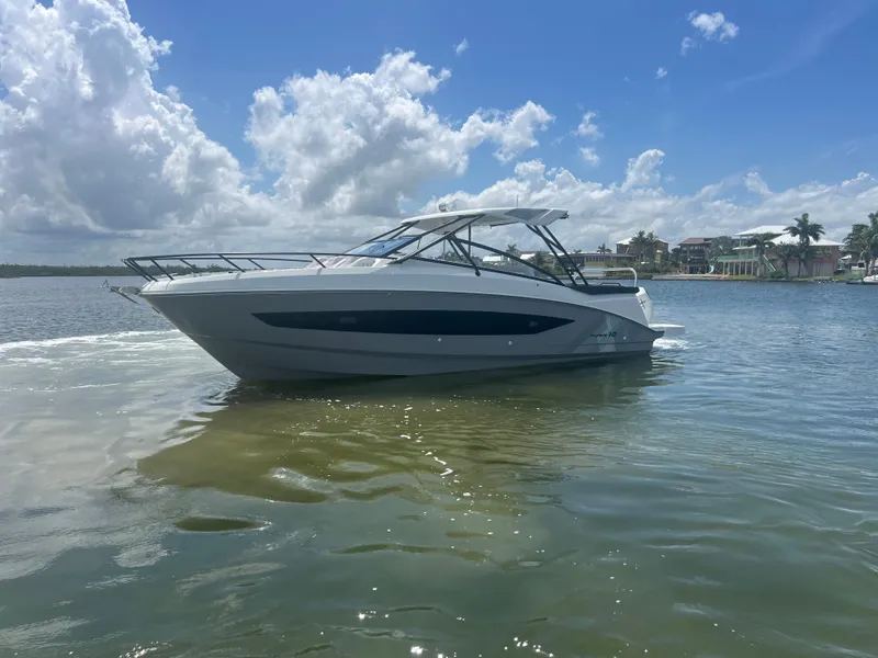 Slide: The Image of 2025 Beneteau Flyer 10 boat on calm water under a partly cloudy sky. - 5