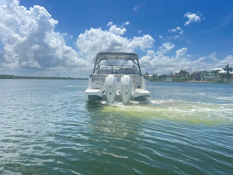 Slide: The Image of 2025 Beneteau Flyer 10 cruising on a sunny day with scenic waterfront views. - 7