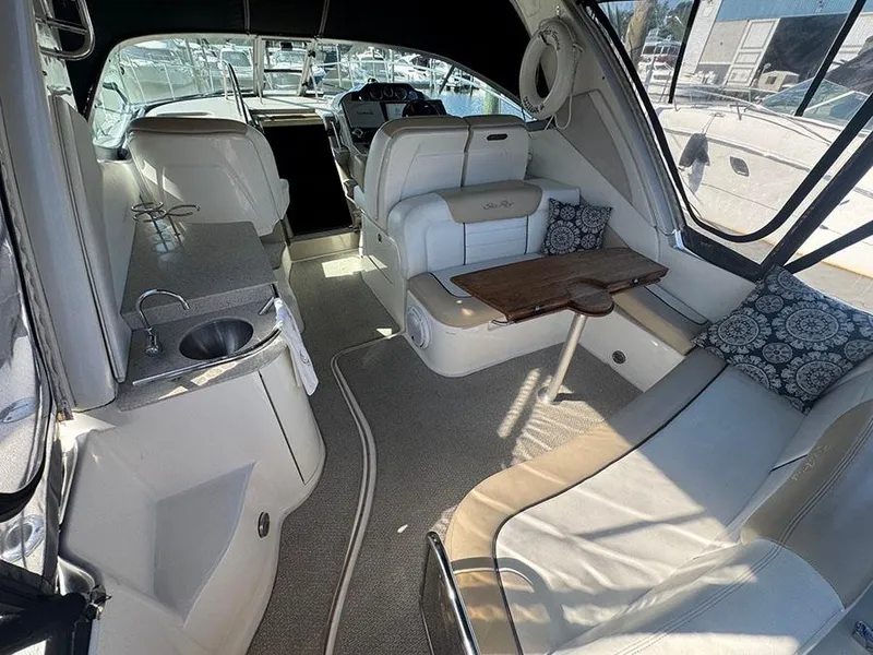 Slide: The Image of 2009 Sea Ray 330 Sundancer interior with seating, table, and kitchenette. - 4