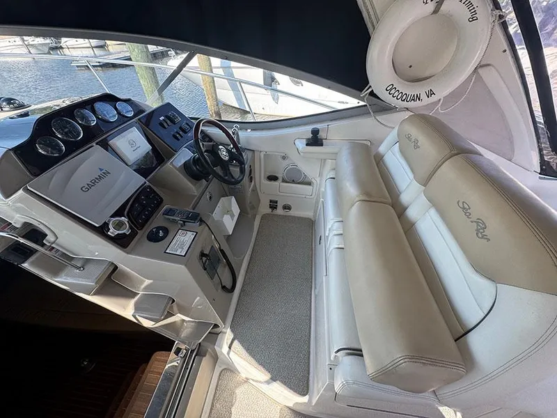Slide: The Image of 2009 Sea Ray 330 Sundancer helm with Garmin navigation, beige seating, and life preserver. - 7