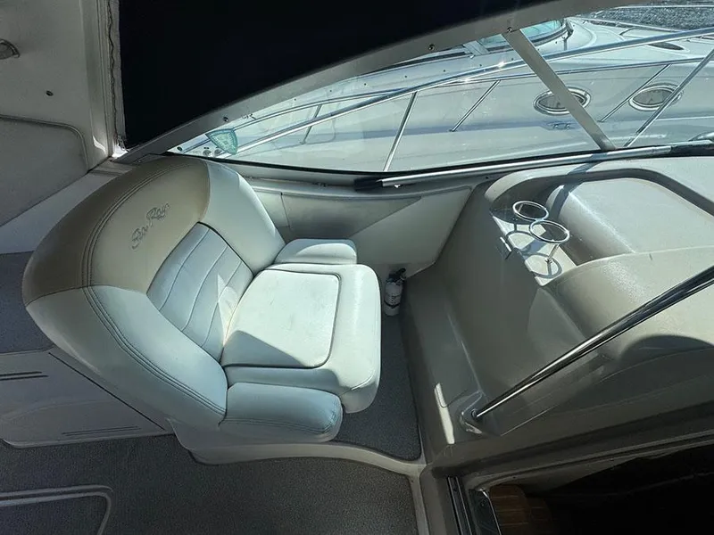 Slide: The Image of Captain's seat in 2009 Sea Ray 330 Sundancer boat cockpit, featuring cup holders. - 8