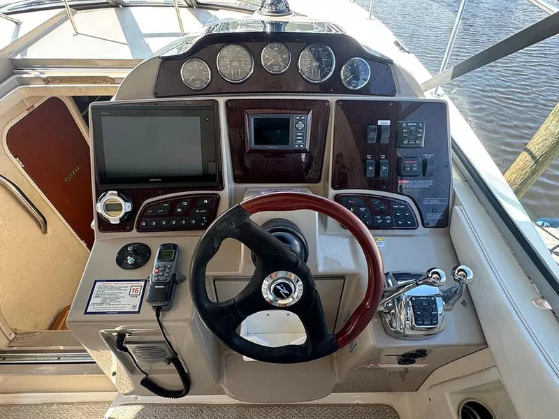 Slide: The Image of 2009 Sea Ray 330 Sundancer helm with steering wheel, gauges, and navigation controls. - 9
