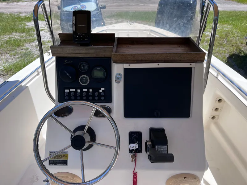 Slide: The Image of Console of a 2000 Scout 185 Sportfish boat with steering wheel and controls. - 11