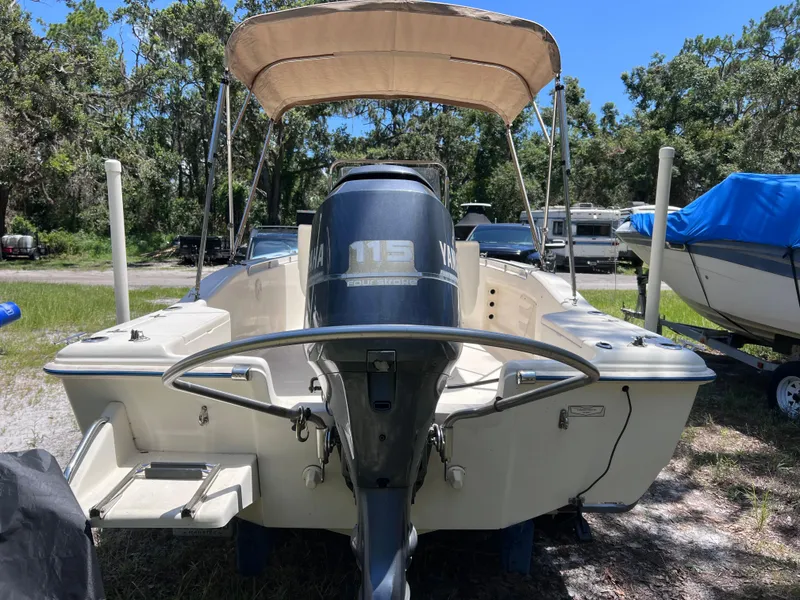 Slide: The Image of 2000 Scout 185 Sportfish boat with Yamaha outboard motor, parked outdoors. - 2