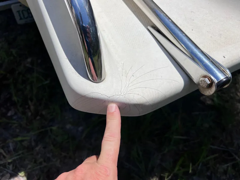 Slide: The Image of Close-up of a crack on a 2000 Scout 185 Sportfish boat's surface, with a finger pointing. - 29