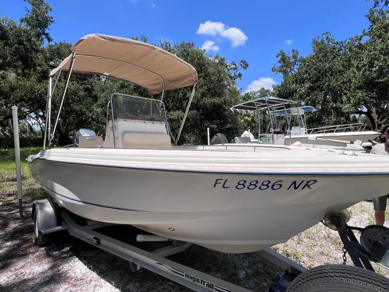 Slide: The Image of 2000 Scout 185 Sportfish boat on trailer with canopy, parked outdoors. - 6