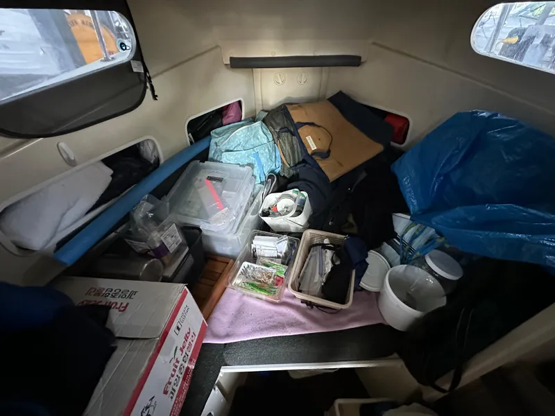Slide: The Image of Interior of a 2007 Rosborough R-246 boat with various stored items. - 16