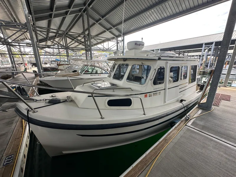 Slide: The Image of 2007 Rosborough R-246 boat docked in a marina under a metal roof. - 2