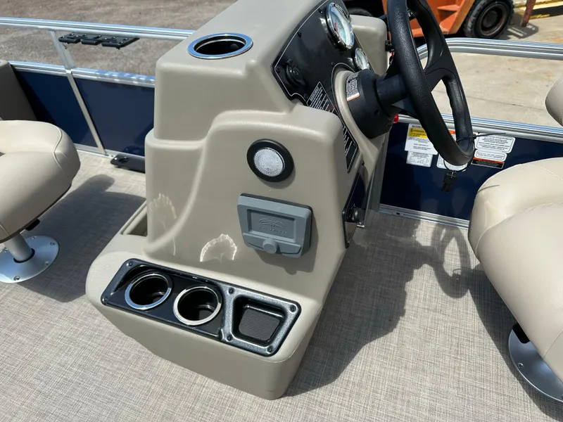 Slide: The Image of 2025 Sun Tracker Bass Buggy 18 DLX boat console with steering wheel and cup holders. - 18