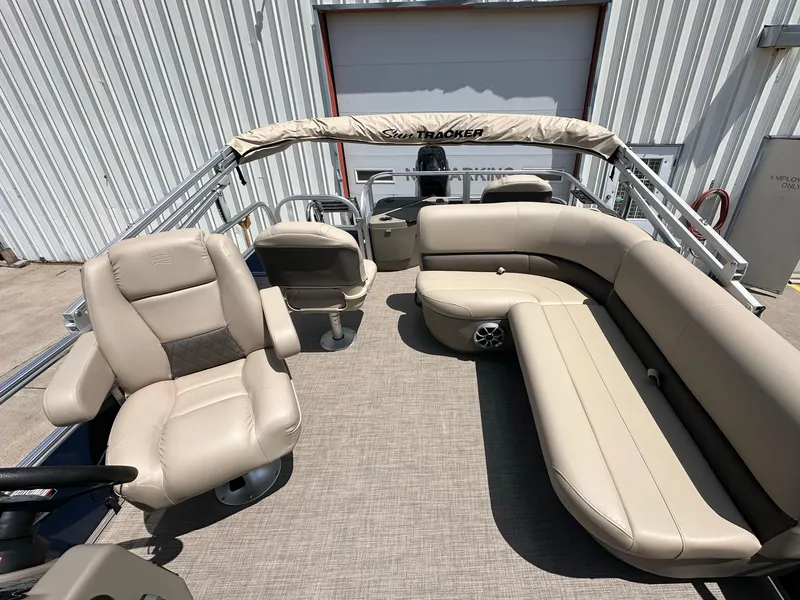 Slide: The Image of 2025 Sun Tracker Bass Buggy 18 DLX pontoon boat with beige seating and spacious interior. - 21