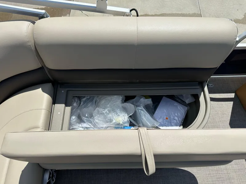 Slide: The Image of Storage compartment in 2025 Sun Tracker Bass Buggy 18 DLX pontoon boat with beige seating. - 22