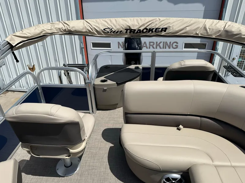 Slide: The Image of 2025 Sun Tracker Bass Buggy 18 DLX pontoon boat interior with beige seating and canopy. - 23