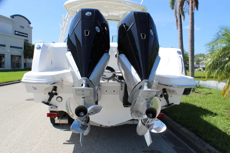 Slide: The Image of 2018 Boston Whaler 270 Vantage boat with dual outboard engines, parked near palm trees. - 11