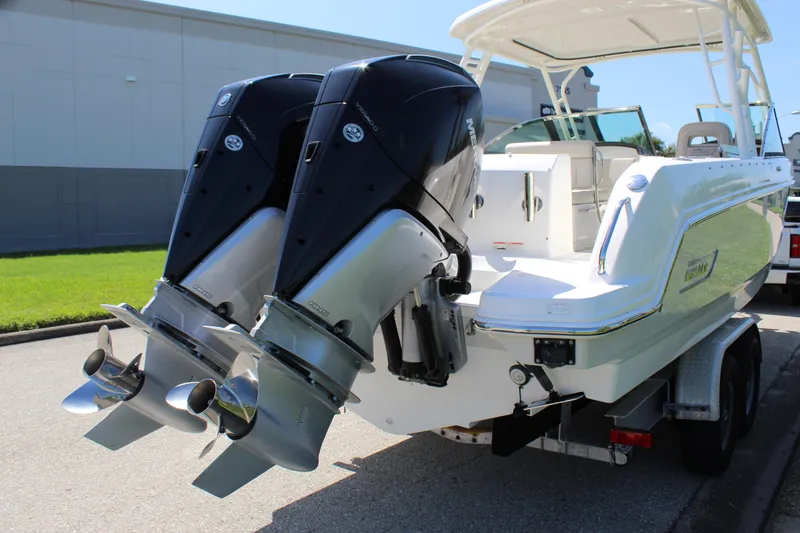 Slide: The Image of 2018 Boston Whaler 270 Vantage with dual outboard engines on a trailer. - 13