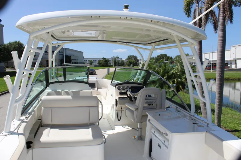 Slide: The Image of 2018 Boston Whaler 270 Vantage boat interior with seating and helm, under clear blue sky. - 23